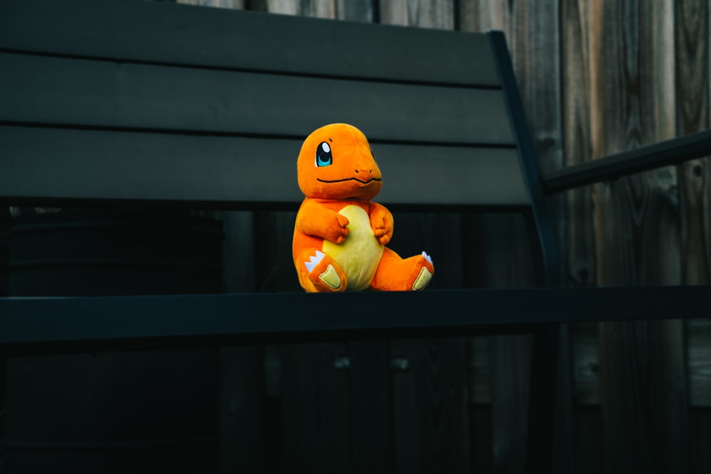 a stuffed toy sitting on top of a wooden bench