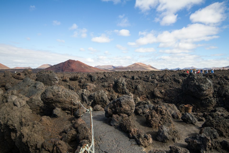 Rugged black lava field with volcanic cones in the distance, Timanfaya National Park, Lanzarote