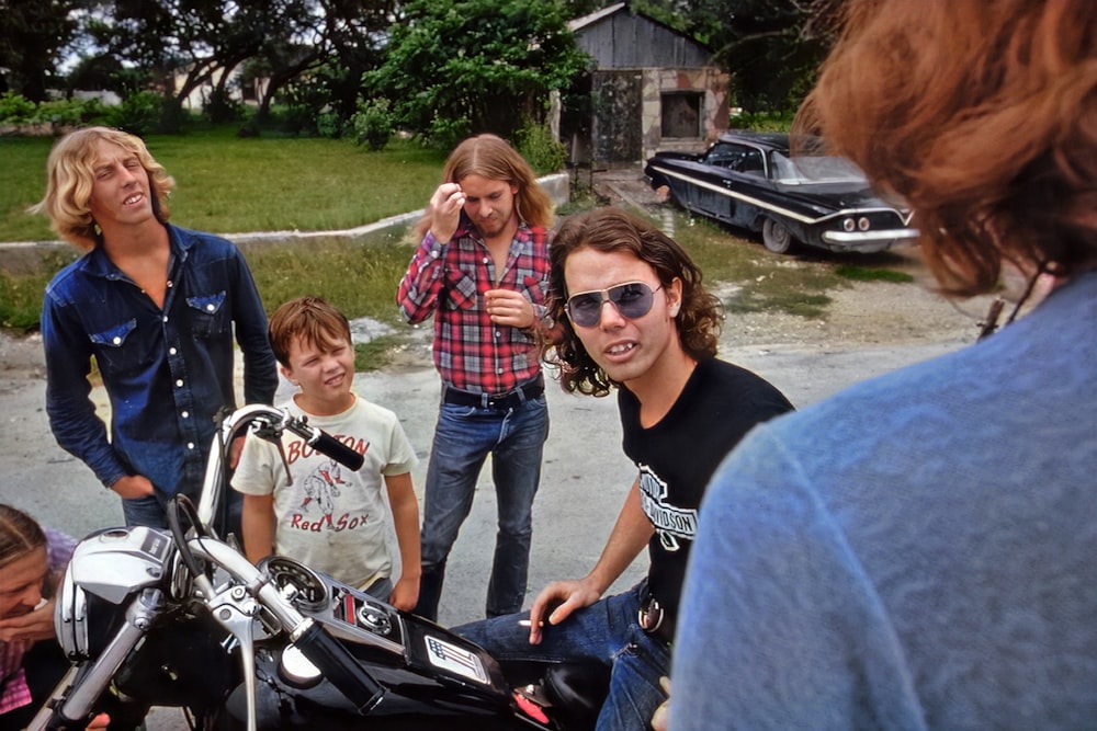 a group of people standing around a motorcycle