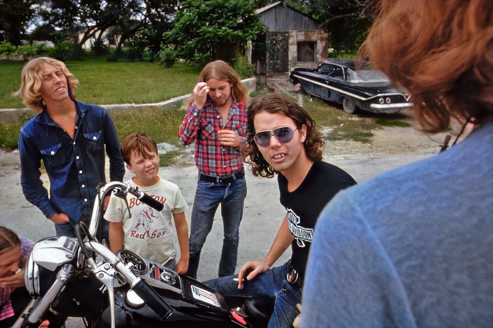 Un grupo de personas de pie alrededor de una motocicleta