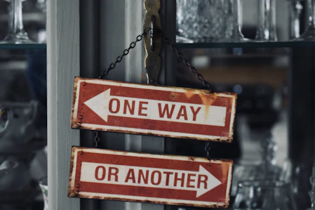 Custom two red and white signs hanging from a metal pole