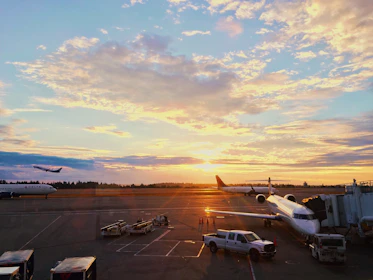 A vibrant airplane taking off from Mumbai airport at sunset.