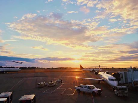 A vibrant sunset over San José airport with a shuttle van waiting to greet arriving passengers.