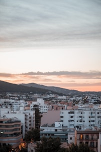 A high-rise apartment building with panoramic city views at sunset.