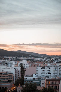 Luxurious modern apartment with panoramic city views at sunset.