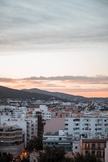 A panoramic view of a bustling cityscape with multiple high-rise apartments at sunset.