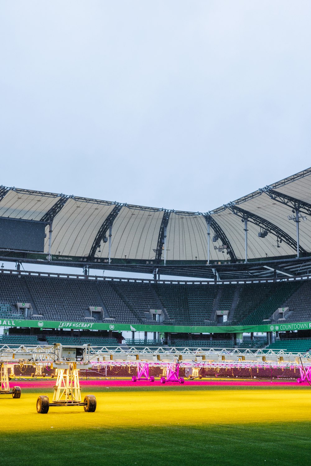 a large stadium with a yellow field in front of it