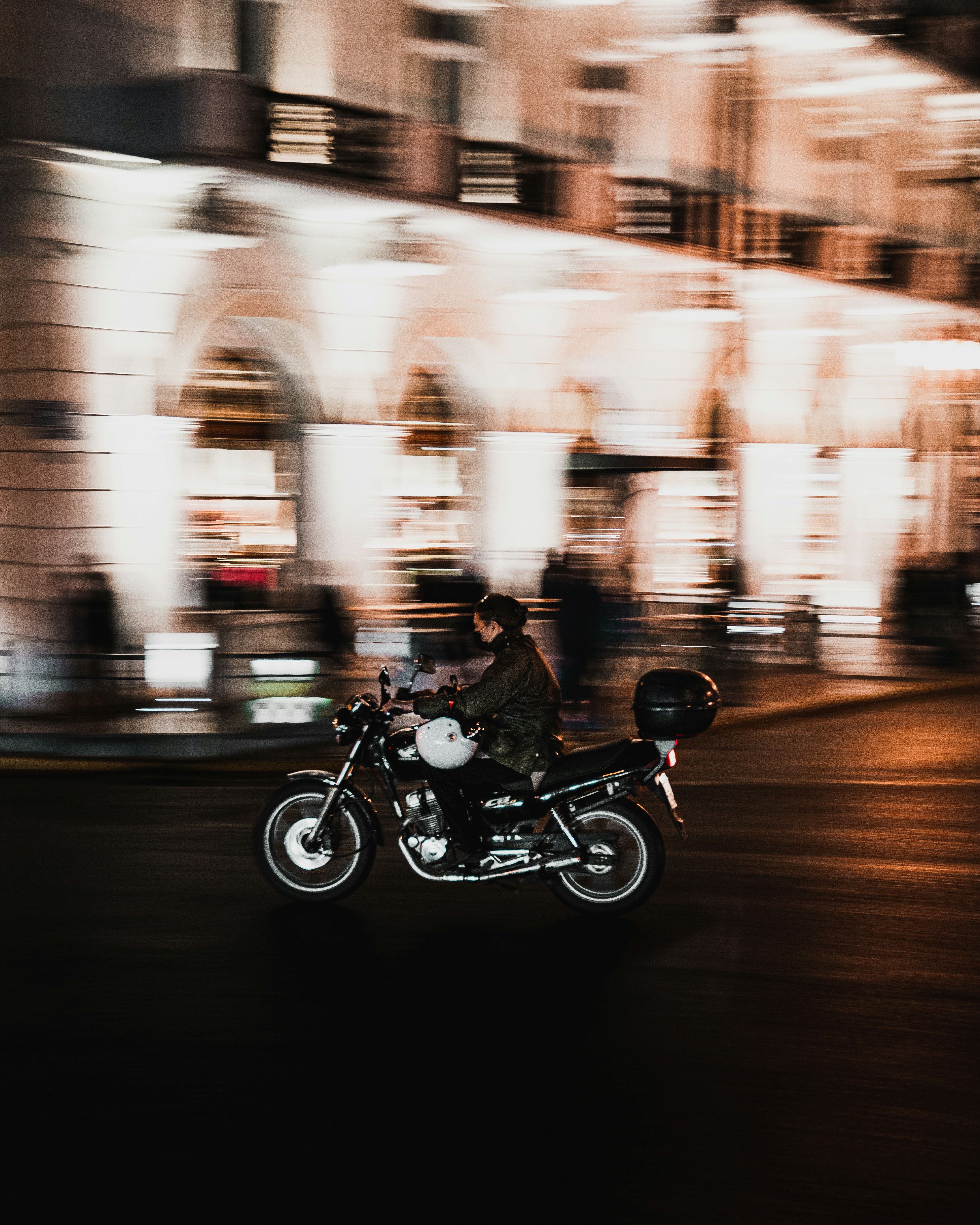 a man riding a motorcycle down a street at night