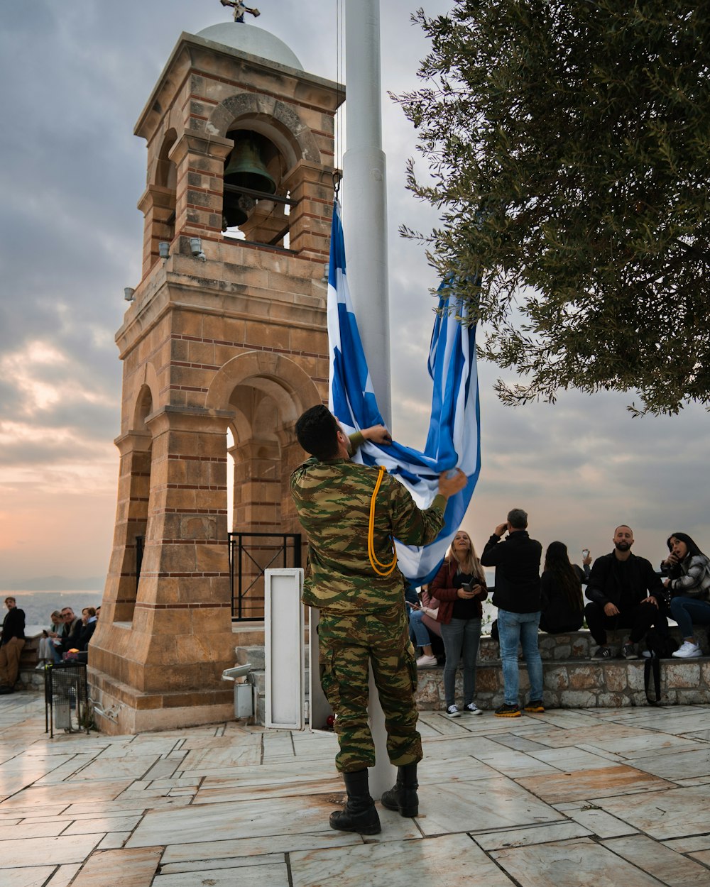 a man holding a flag next to a clock tower