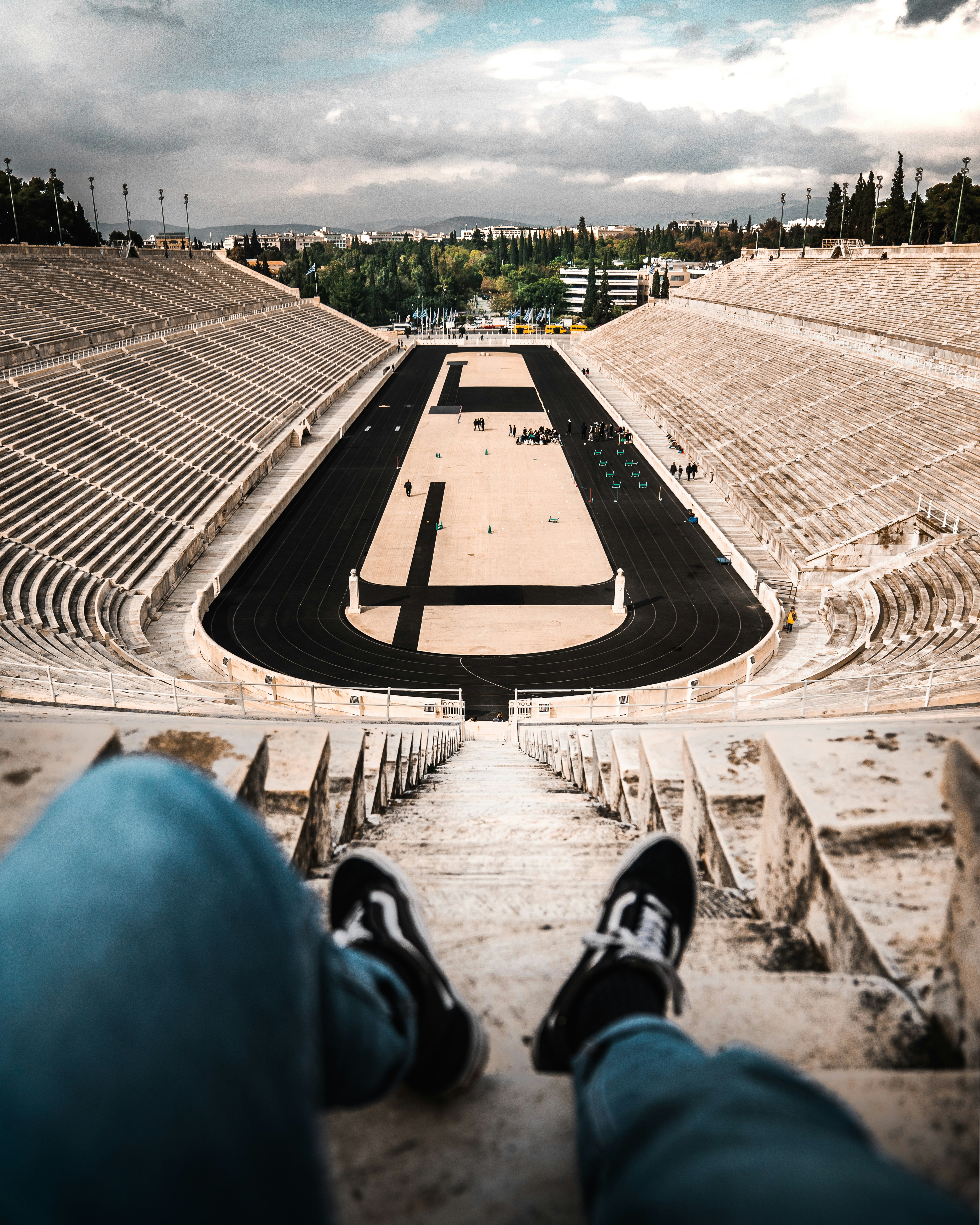 a person's feet are on the steps of a stadium