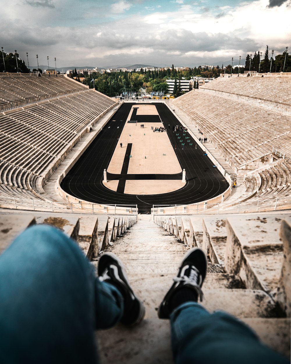 a person's feet are on the steps of a stadium