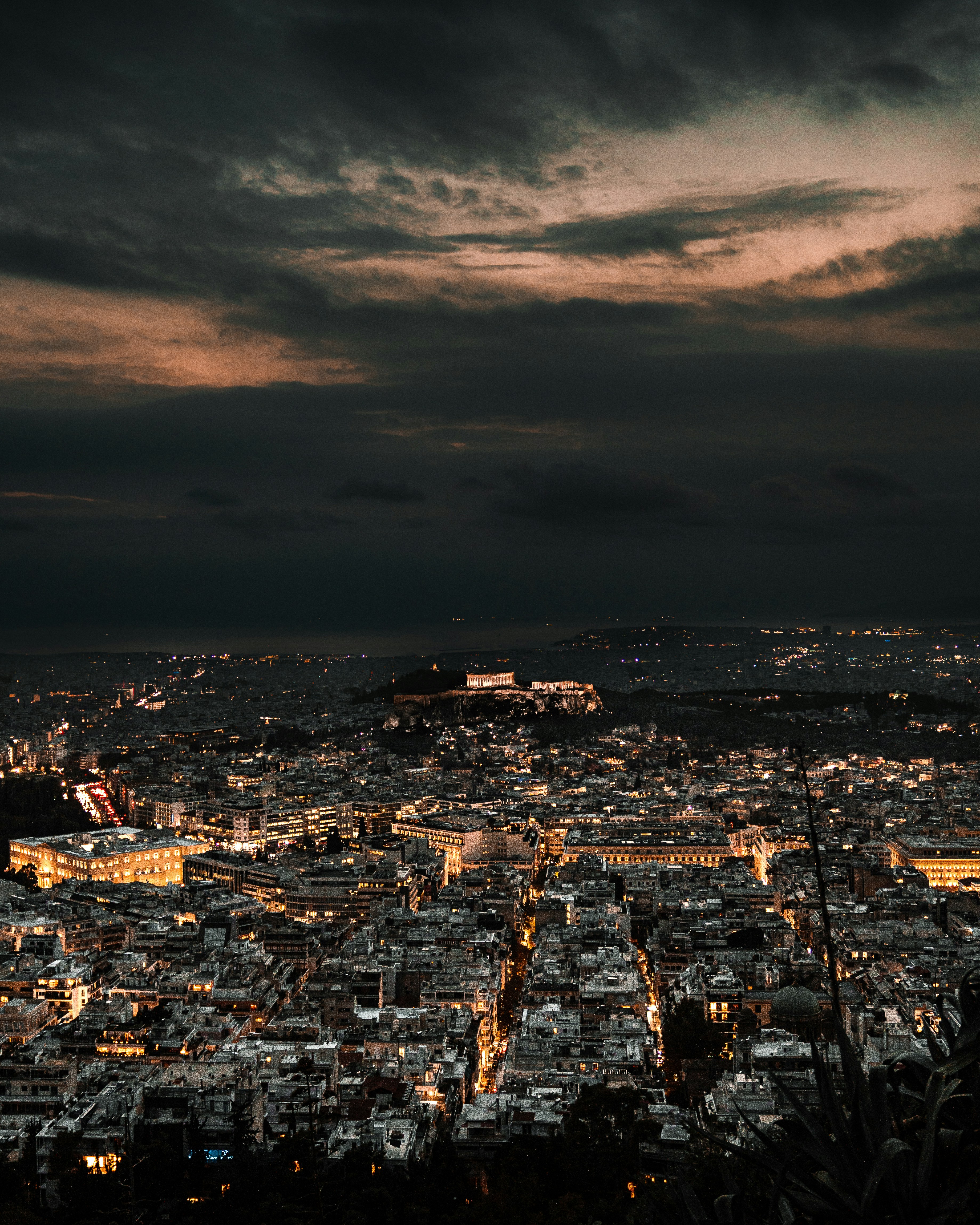 a view of a city at night from the top of a hill