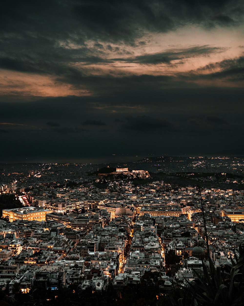 a view of a city at night from the top of a hill