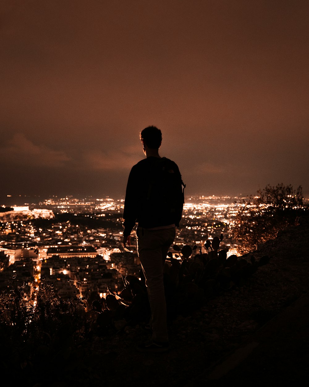 a man standing on top of a hill at night