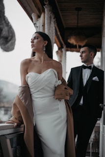 a woman standing next to a man in a suit and tie