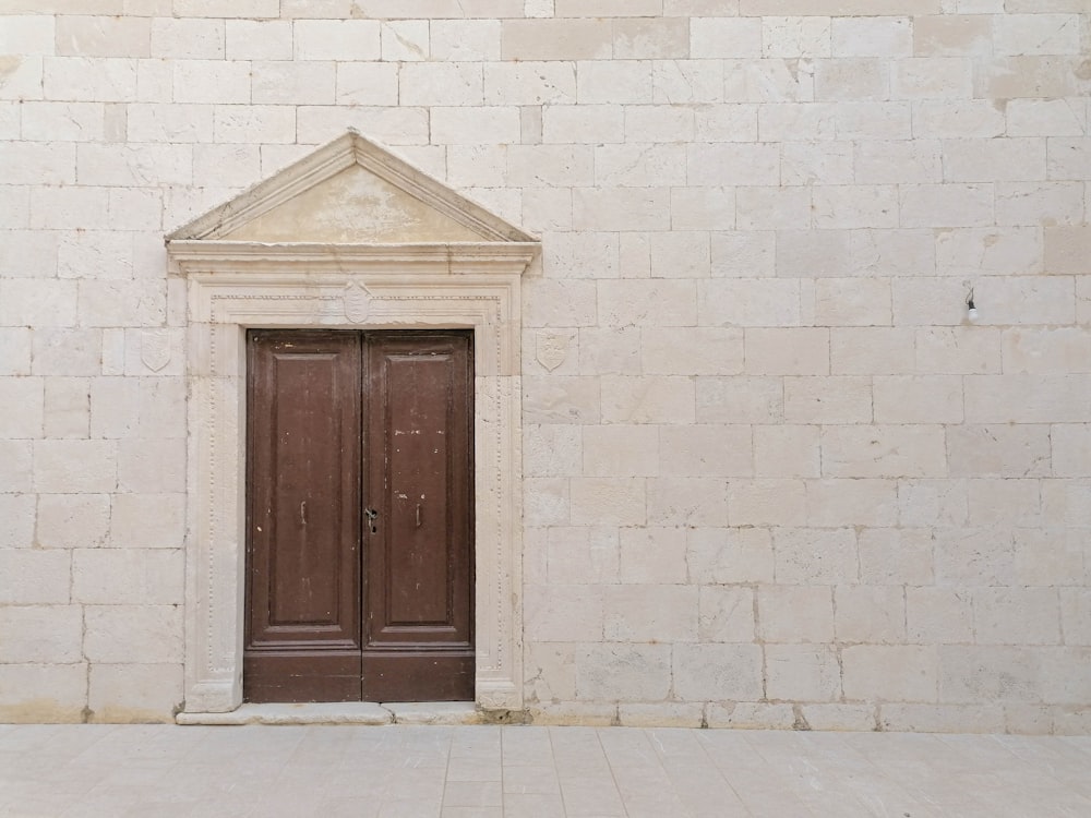 a brown door is on a white brick wall