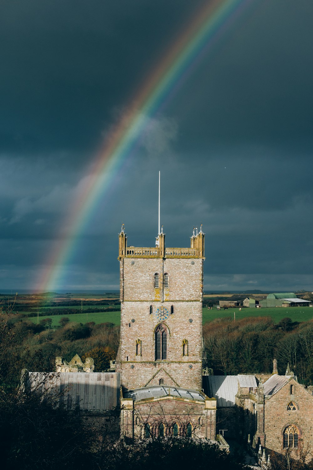 a rainbow shines in the sky over a castle
