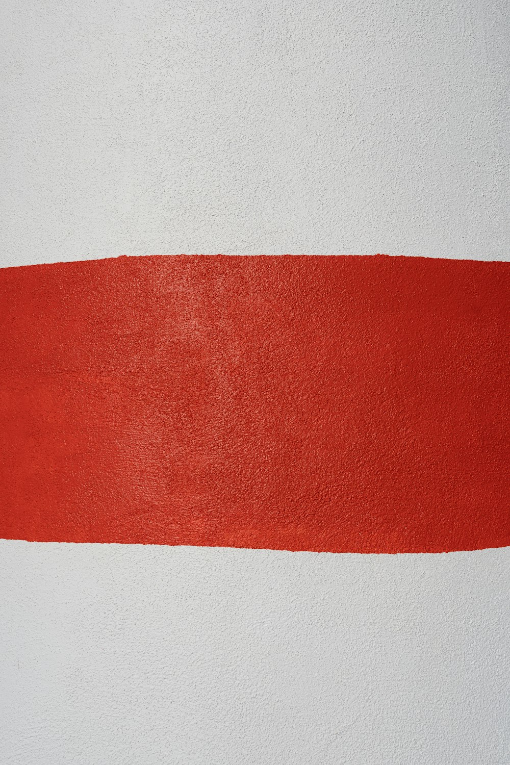 a white wall with a red strip painted on it