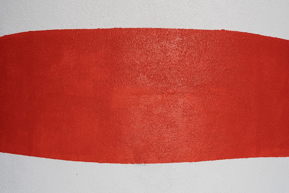 a red and white painting on a white wall
