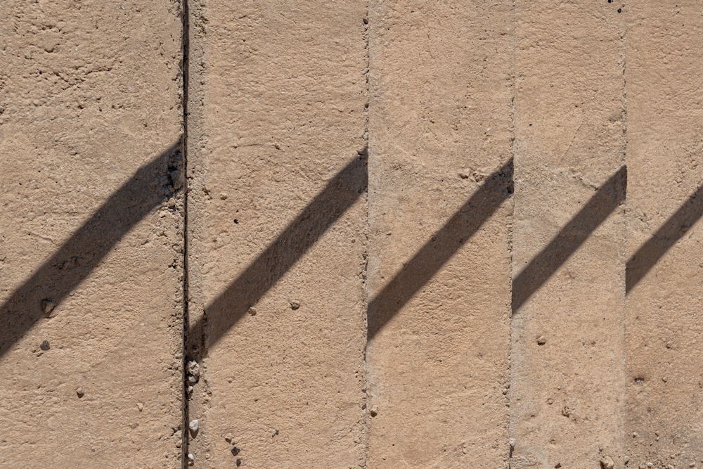 a shadow of a person walking down a sidewalk