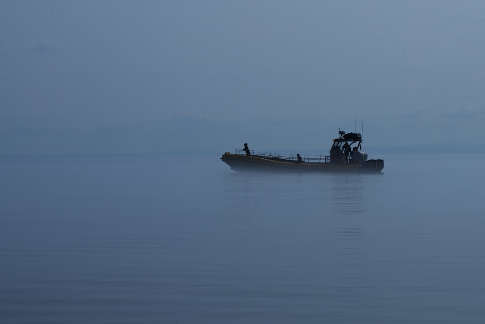 a boat in the middle of the ocean on a foggy day