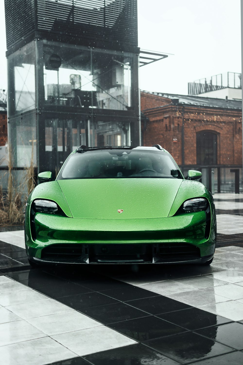 a green sports car parked in front of a building