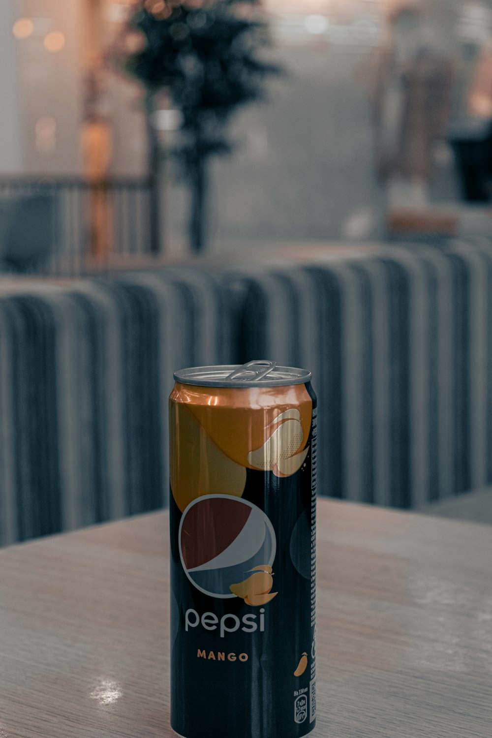 a can of pepsi sitting on top of a wooden table
