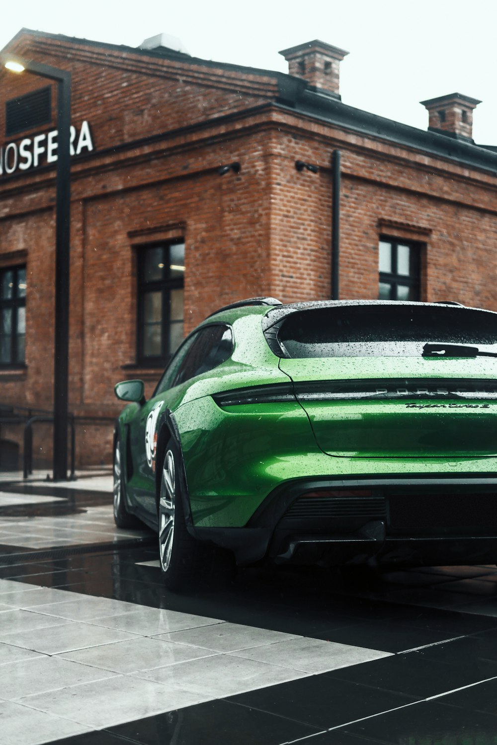 a green sports car parked in front of a building