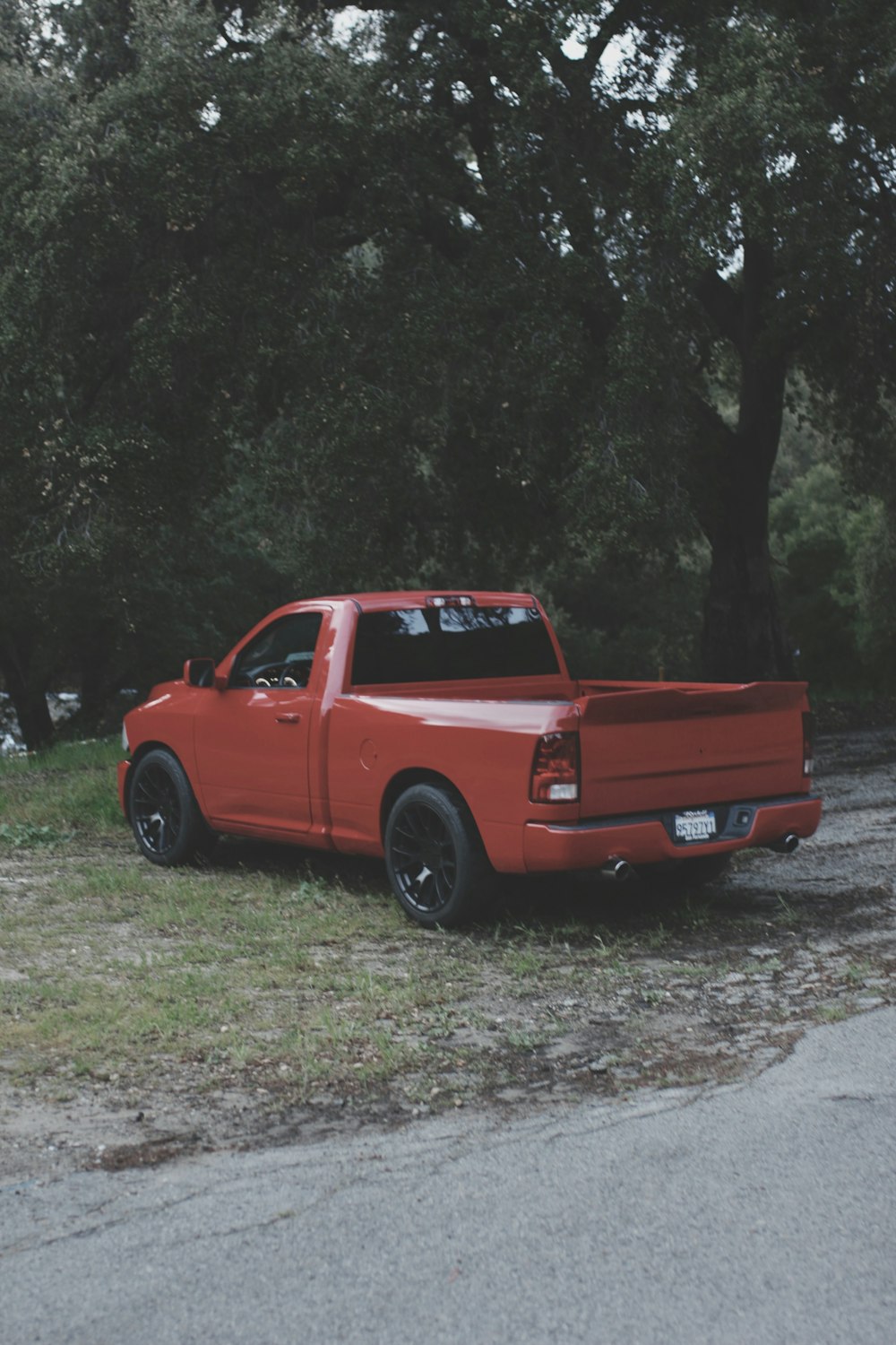 a red pick up truck parked on the side of a road