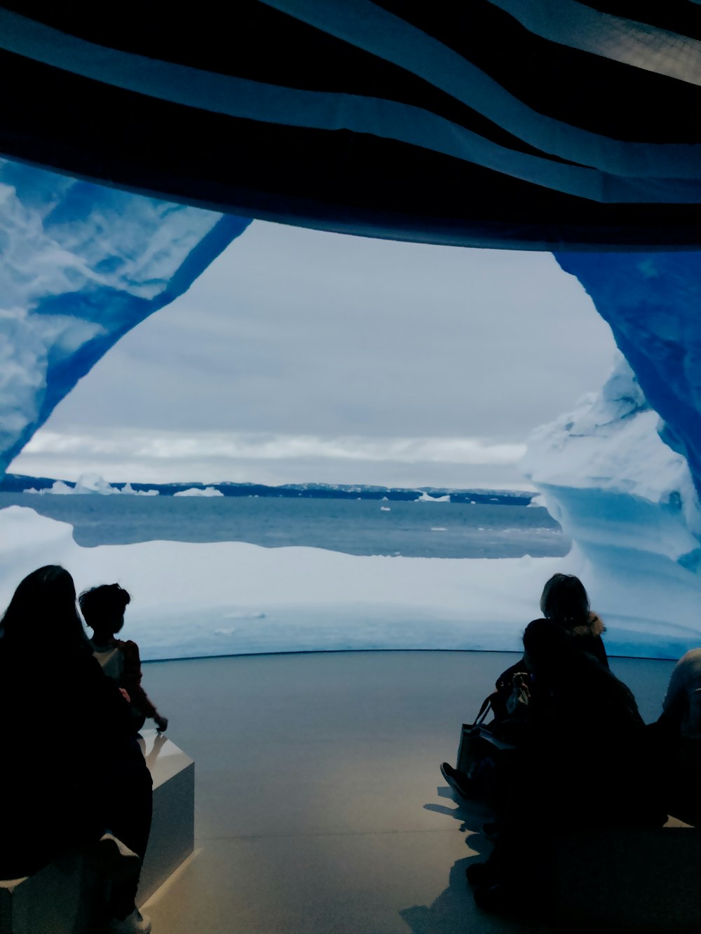 un groupe de personnes assises devant un iceberg