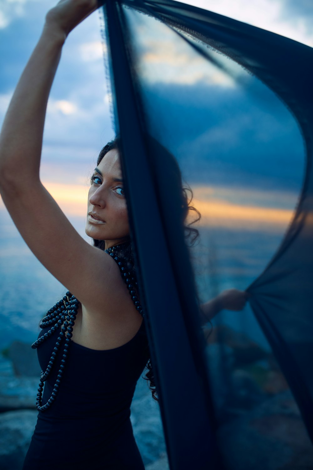 a woman in a black dress holding a black umbrella