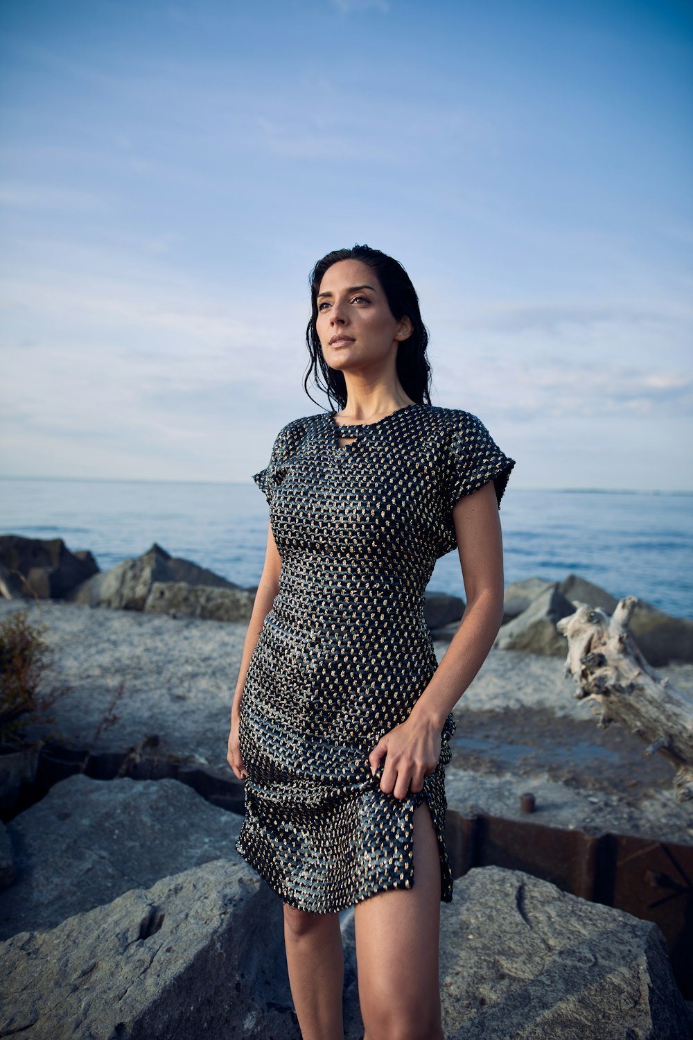 a woman standing on a rock near the ocean