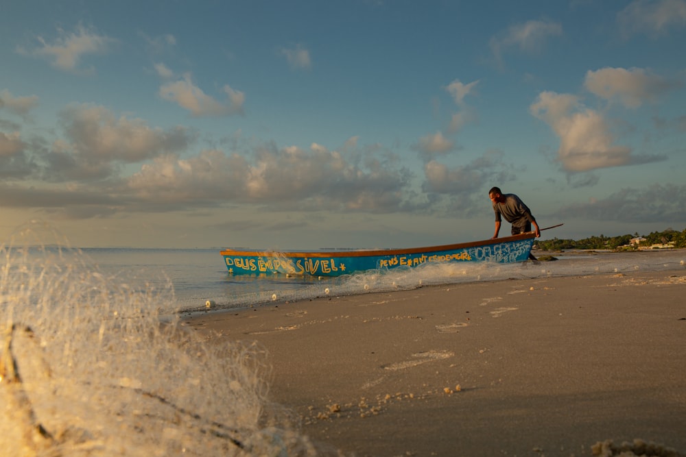 a man riding a boat on top of a sandy beach