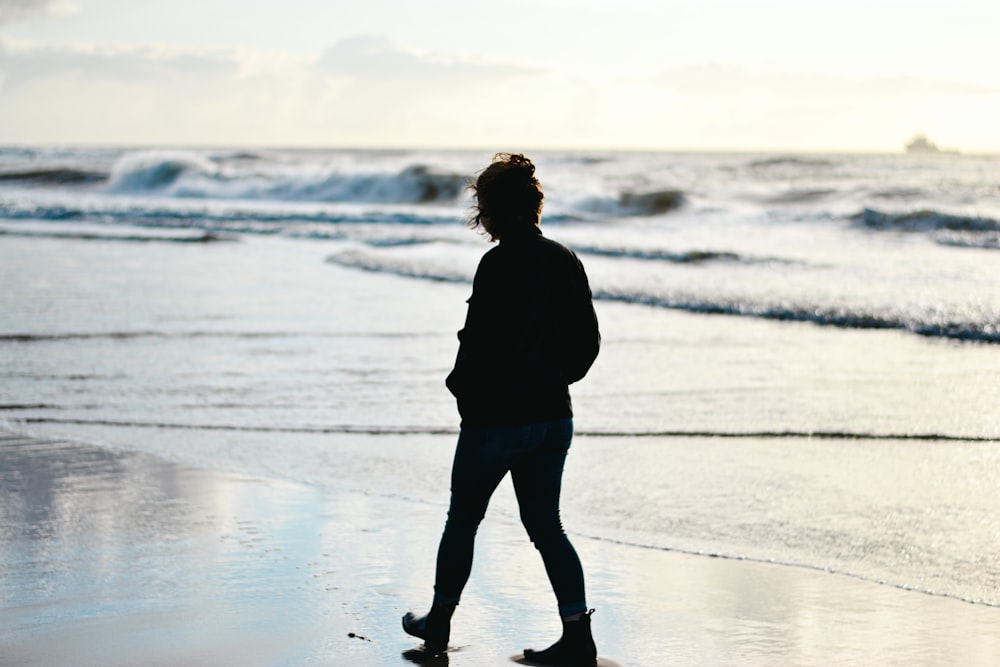 a person standing on a beach next to the ocean