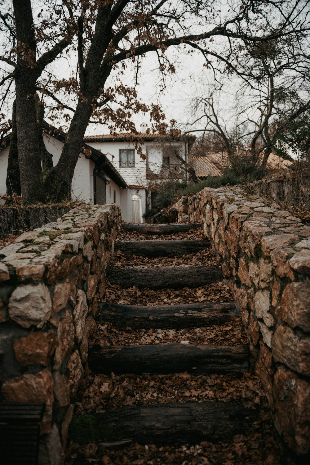 a stone wall with steps leading up to a house