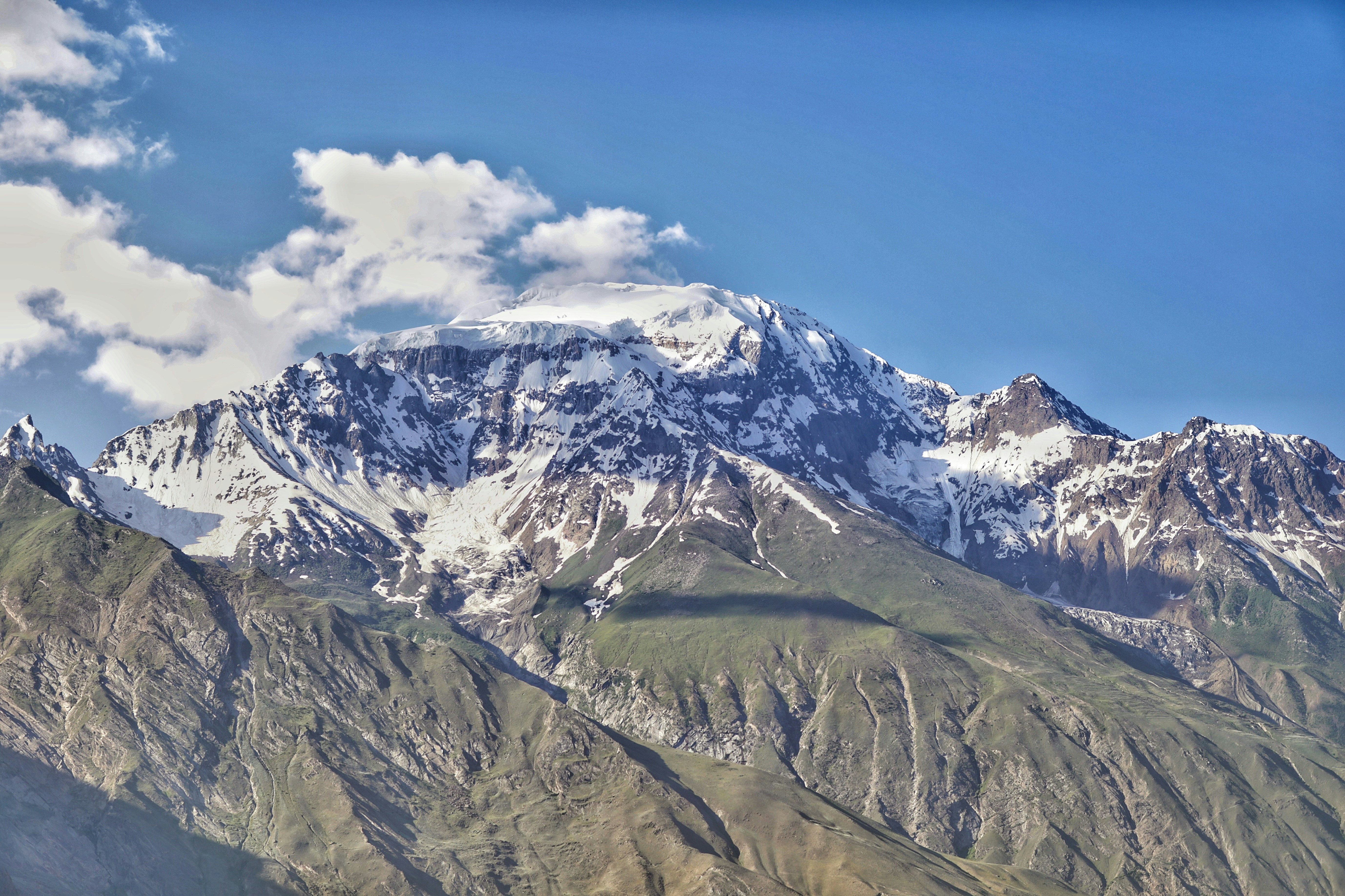 a snow covered mountain with clouds in the sky