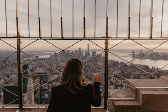 a woman standing on top of a tall building