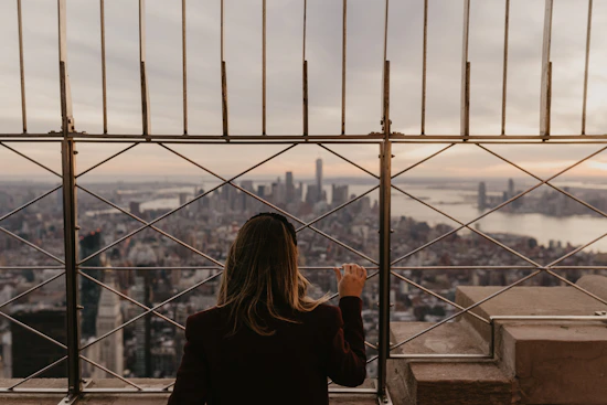 a woman standing on top of a tall building