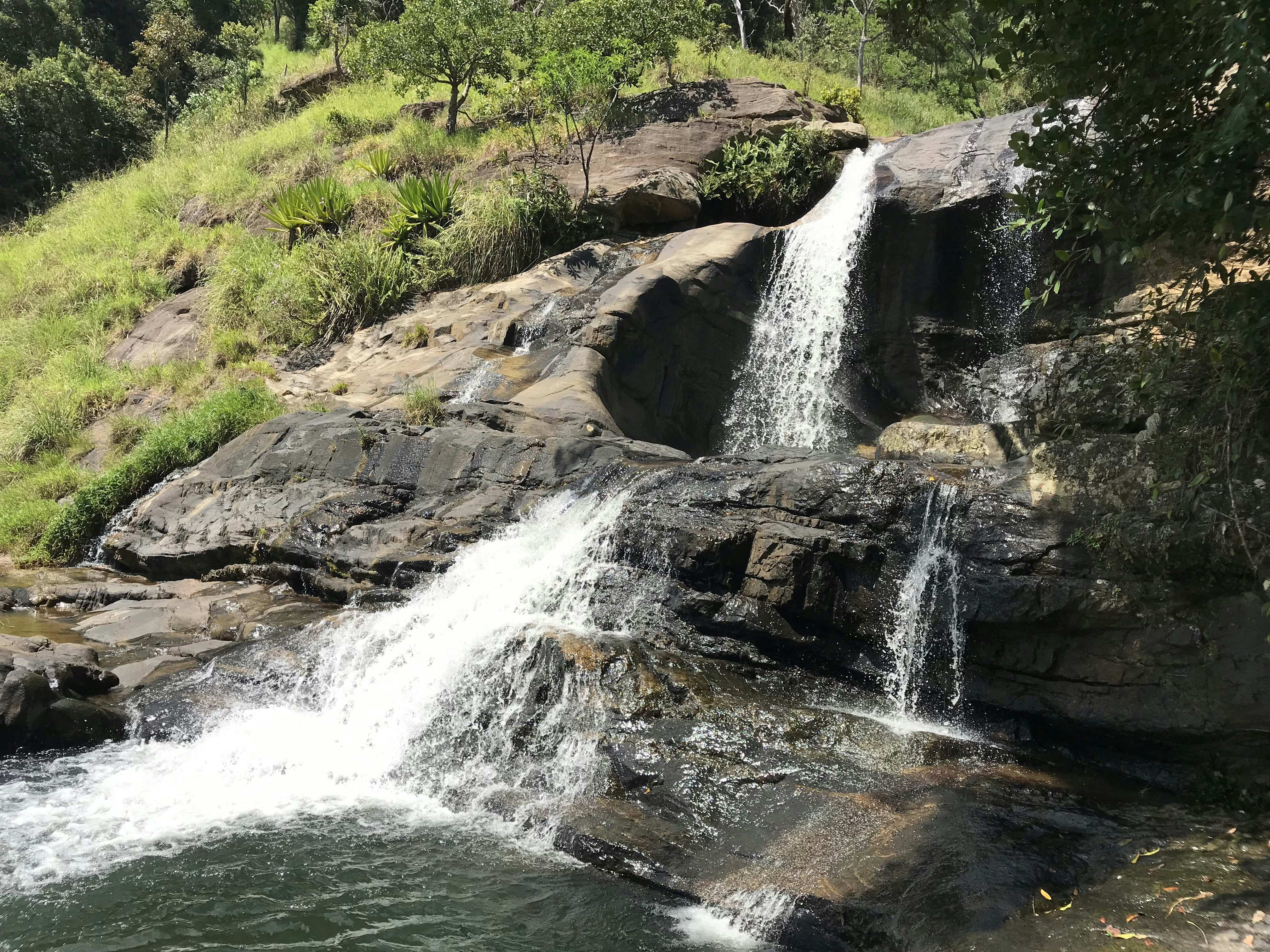a waterfall with a man standing on top of it