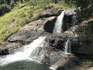 a waterfall with a man standing on top of it