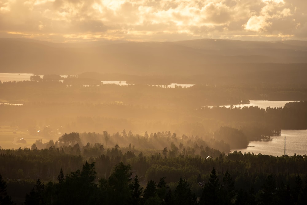 the sun shines through the clouds over a lake