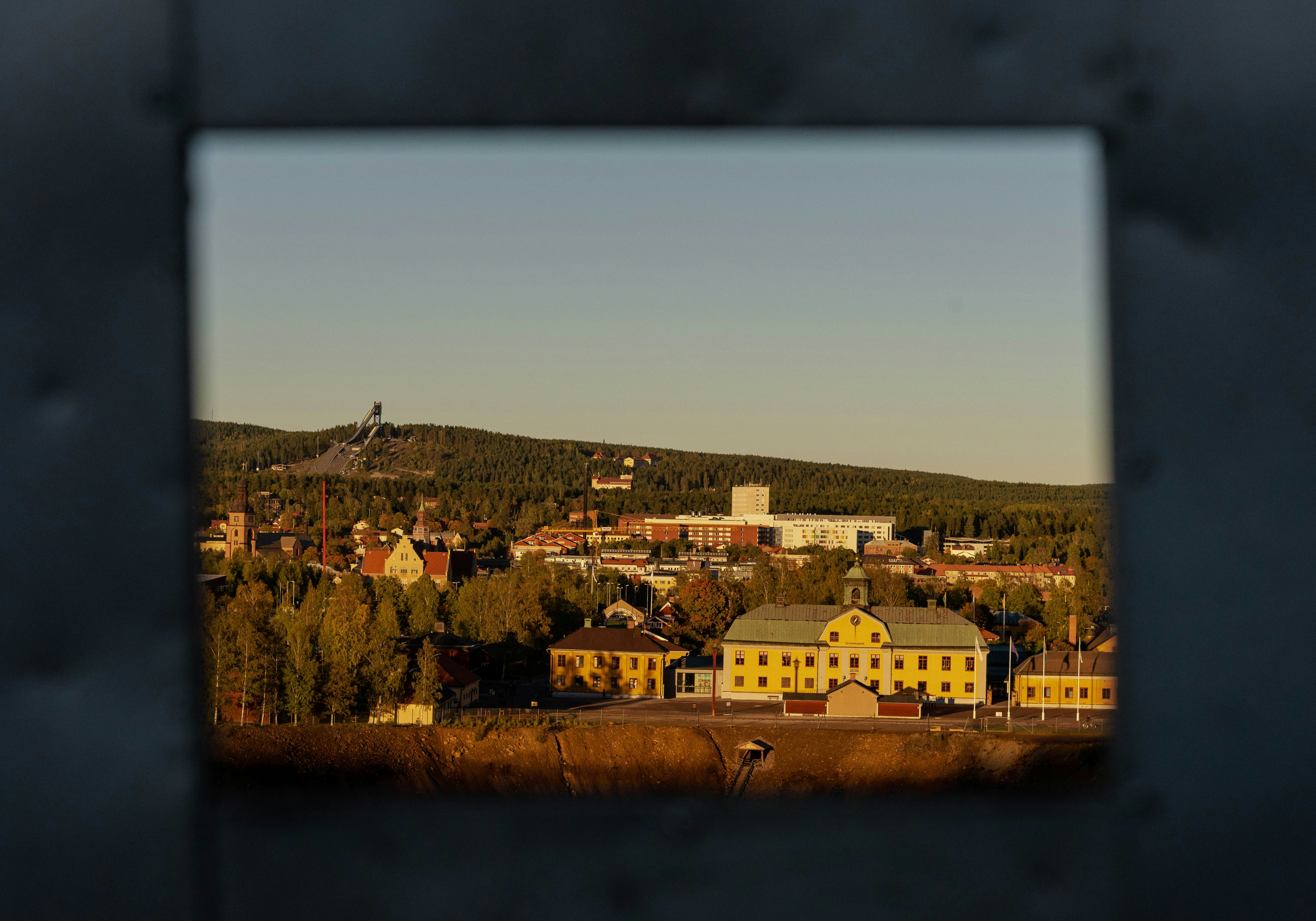 a view of a town through a hole in a wall