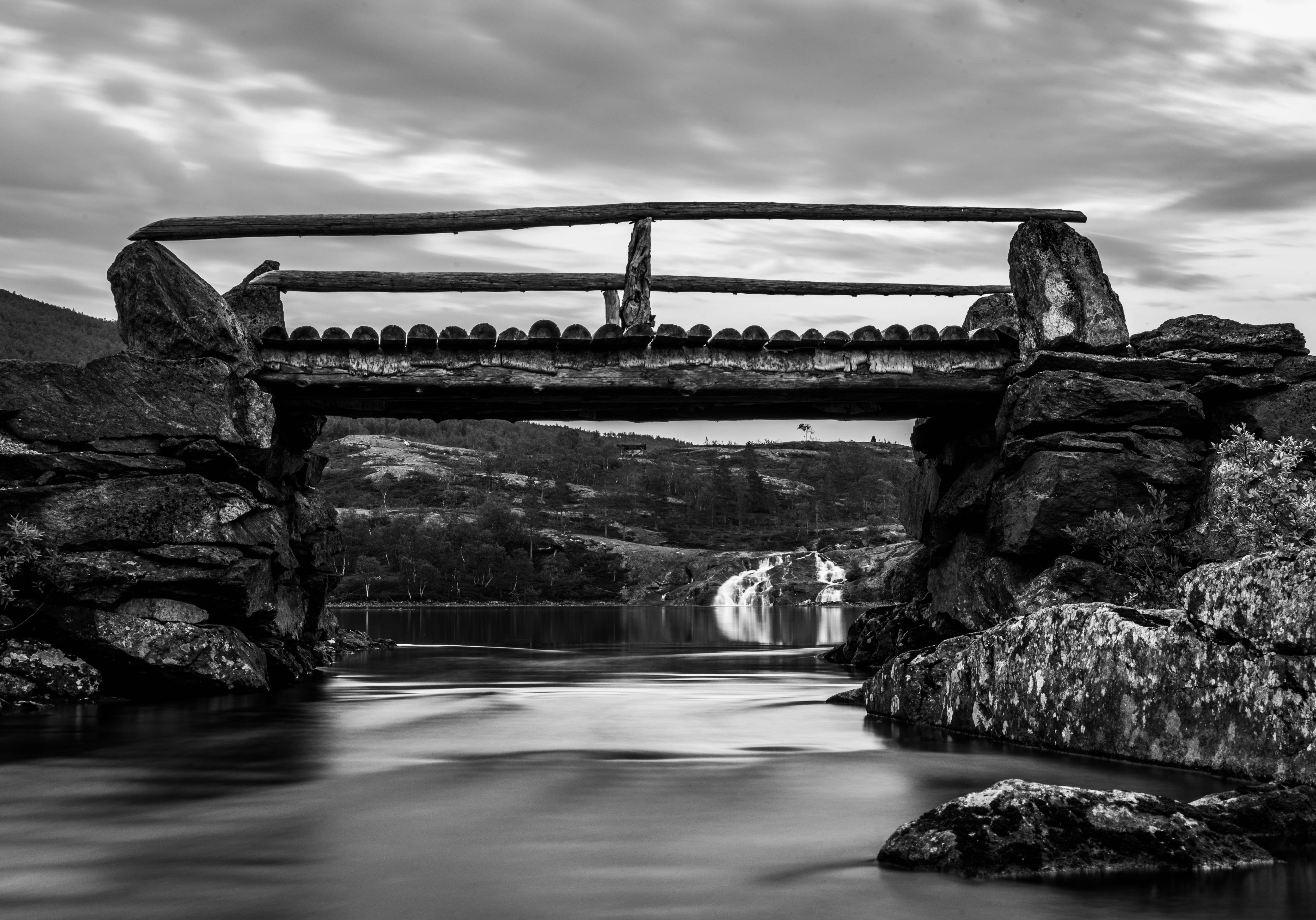a black and white photo of a bridge over a river