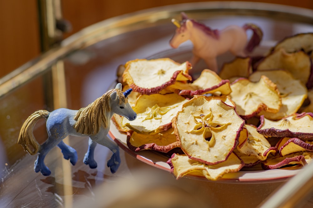 おもちゃの馬が食べ物の皿の上にあります