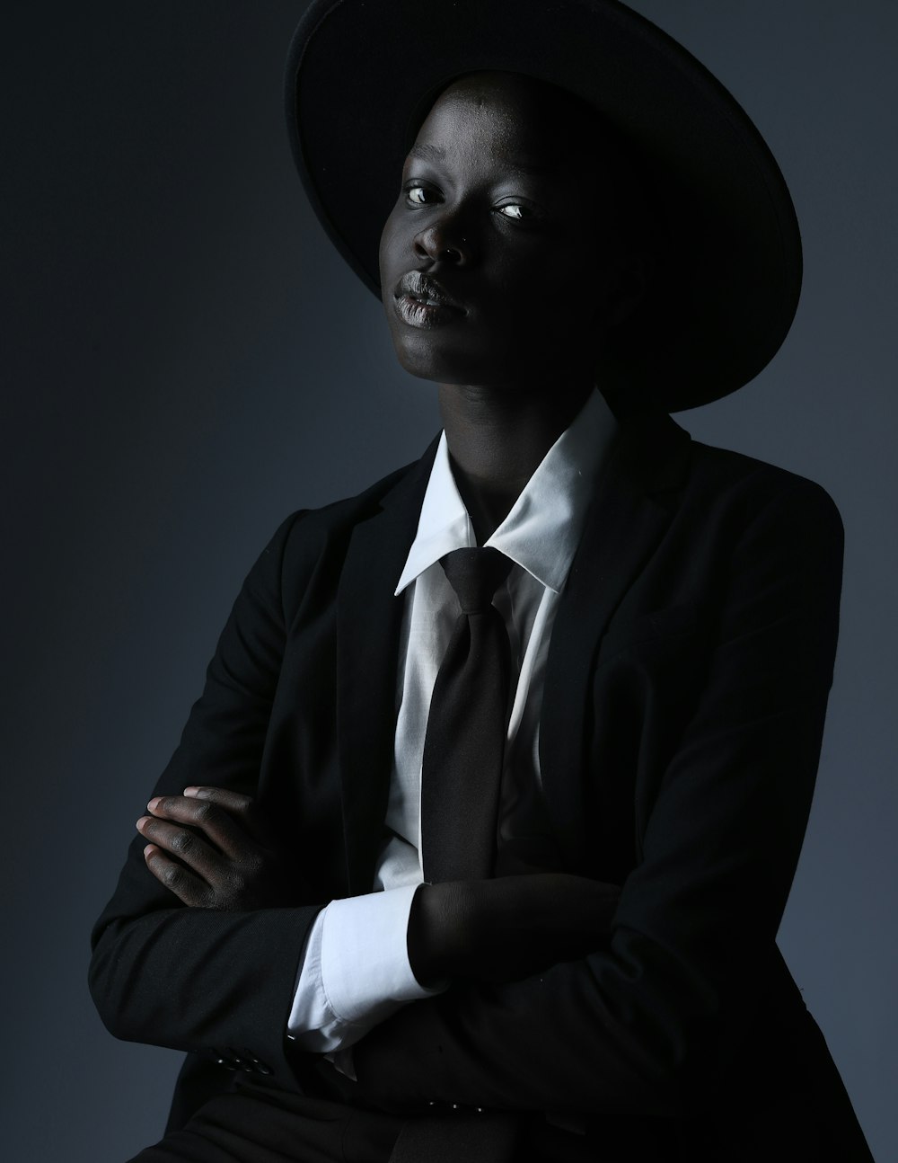 a woman in a suit and hat posing for a picture
