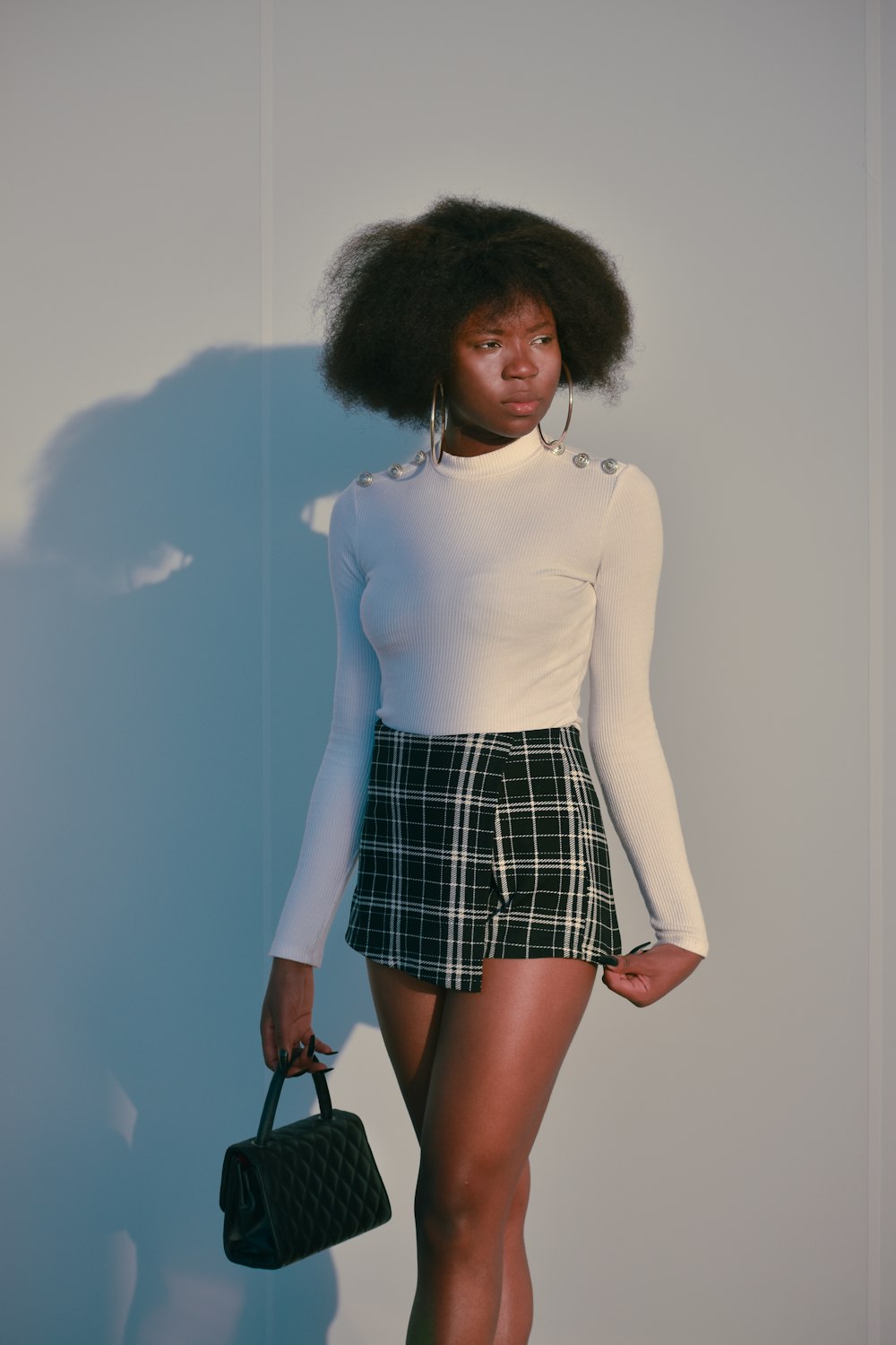 a woman in a white shirt and plaid skirt