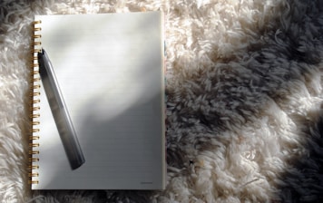 a notebook with a pen on top of it
