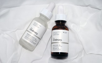 a couple of bottles of liquid sitting on top of a bed