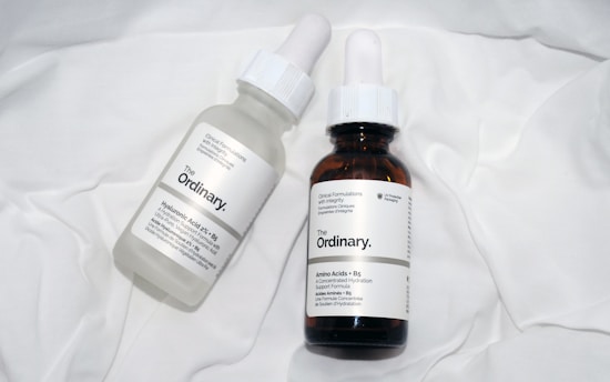 a couple of bottles of liquid sitting on top of a bed