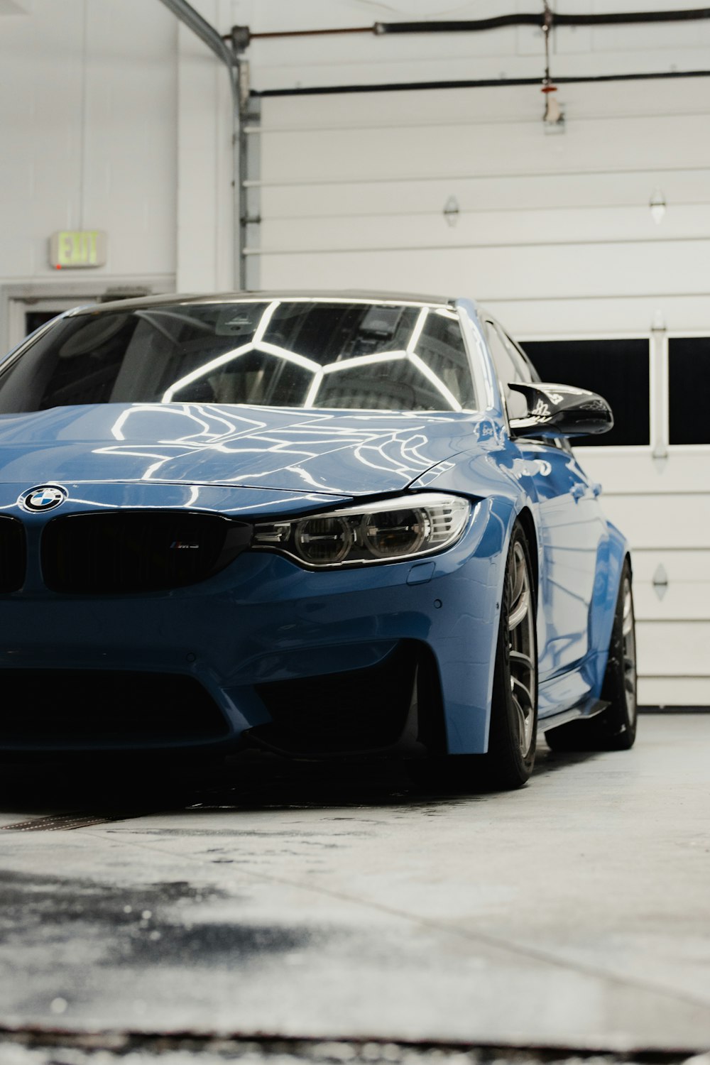 a blue car parked in a garage next to a garage door